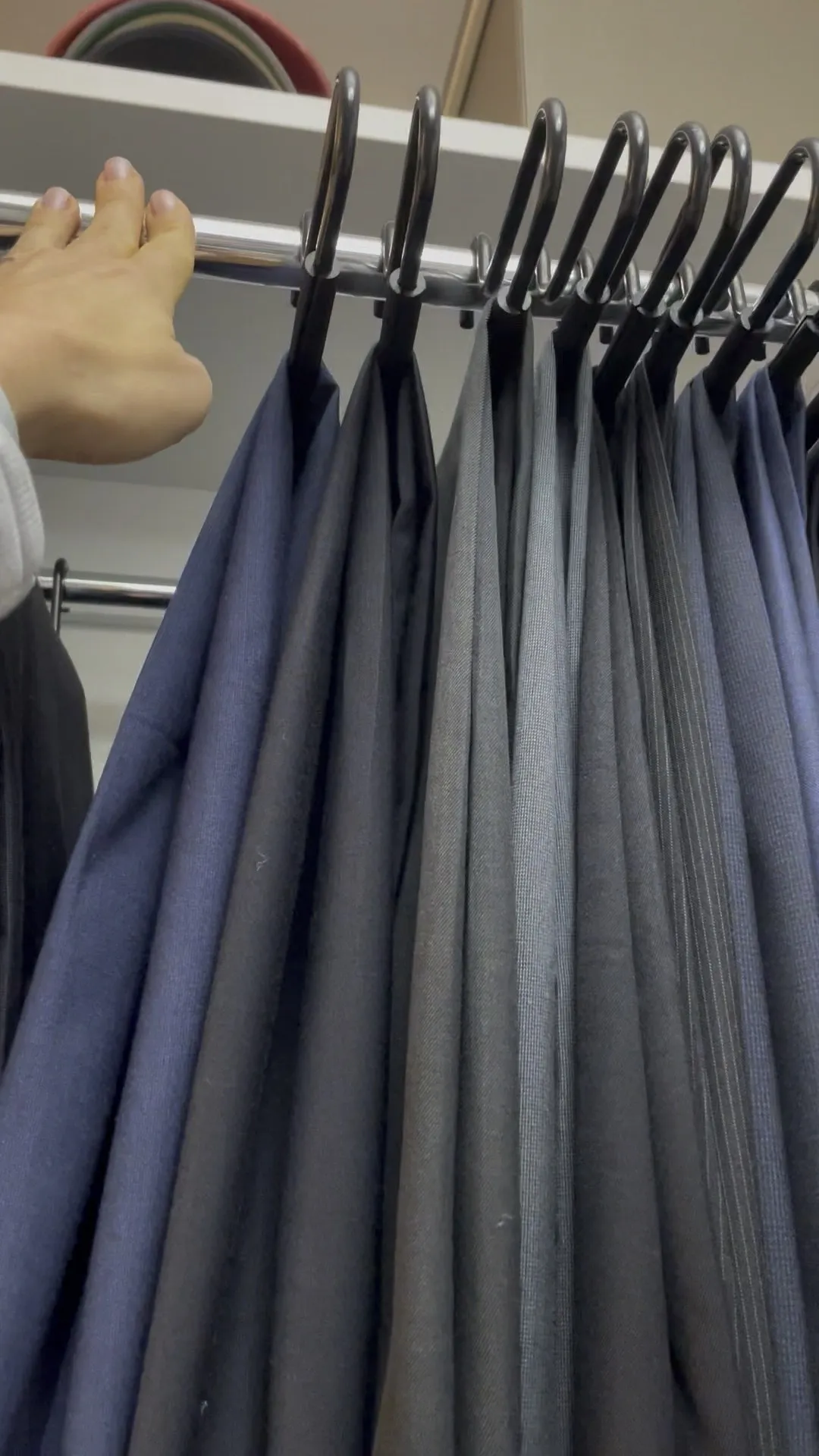 Dress pants on matching hangers, sorted by color
